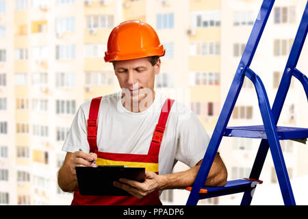 Construction supervisor writes on clipboard. Stock Photo