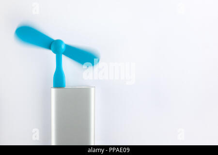 Blue mobile usb fan installed in powerbank on white background Stock Photo