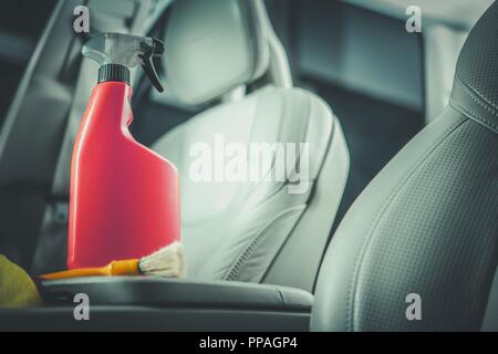 Car Leather Cleaning Detergent in the Orange Red Bottle. Modern Vehicle Interior with Light Leather Finishing. Stock Photo