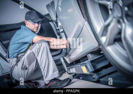 Car Mechanic and the Vehicle Fixing. Caucasian Automotive Technician in His 30s Spotting the Problem. Stock Photo