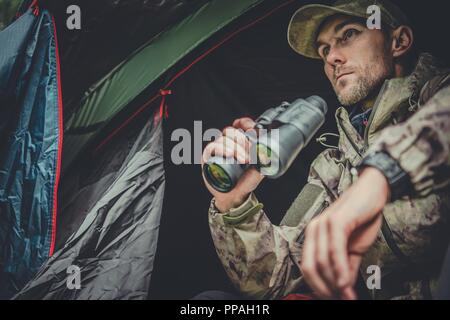 Caucasian Hunter Spotting Wildlife From His Tent in Remote Place. Stock Photo