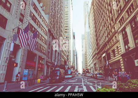 NEW YORK - SEPTEMBER 2, 2018: New York City street road in Manhattan at summer time, many cars, yellow taxis and busy people walk to work. Stock Photo