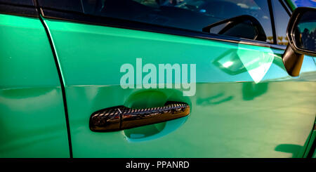 Green car with bronze handle and side mirror Stock Photo