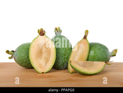 Whole Pineapple guava on a wood table with sliced fruit in half and quarters. Stock Photo
