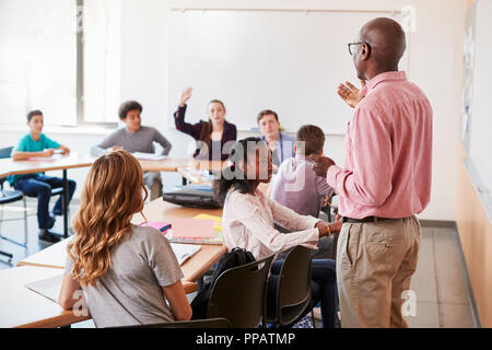 Male High School Tutor Standing At Whiteboard Teaching Class Stock Photo