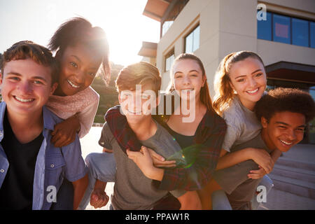 Portrait Of High School Students Giving Each Other Piggybacks College Buildings Stock Photo