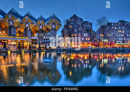 Rotterdam, The Netherlands, February 26, 2016: The Cube Houses and other residential buildings, designed by Piet Blom in the 1980's reflect in the cal Stock Photo