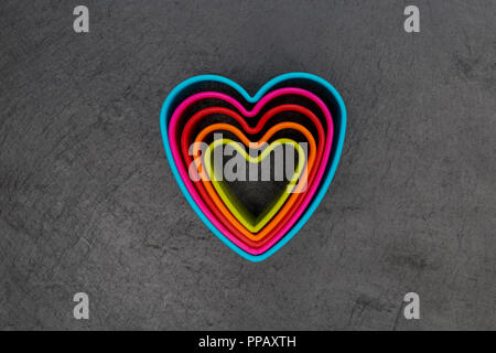 Cookie cutter love heart shape on dark background Stock Photo