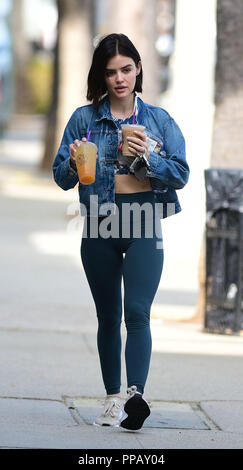 Lucy Hale wears a red 'LA' hat with denim jacket and black leggings during  a coffee