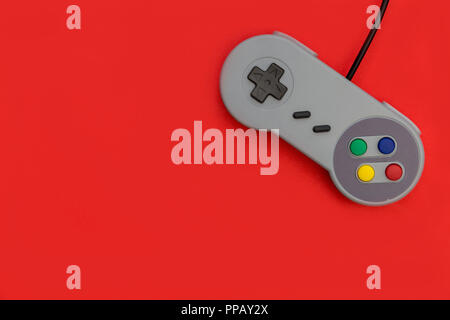 Retro video game controller on red background Stock Photo