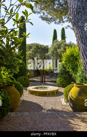 small garden in the Provence with fountain and amphores, old village Ménerbes, France, situated on a hill, department Vaucluse, Luberon mountains Stock Photo