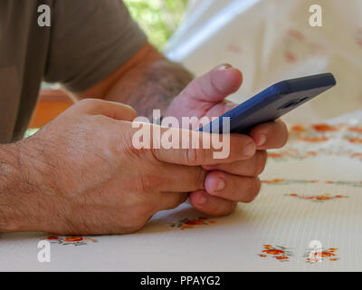 Closeup image of a man holding , using and looking at smart phone Stock Photo