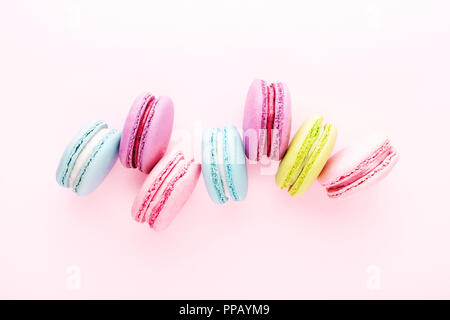 Colorful macarons cookies on pink background. Top view, minimal. Stock Photo