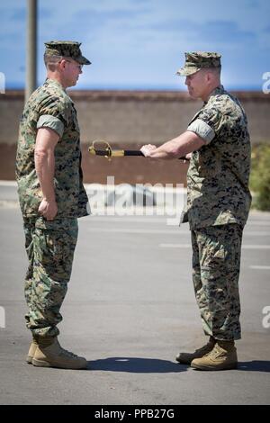 U.S. Marine Corps Sgt. Maj. Bryan L. Marzzarella, right, outgoing battalion sergeant major, 1st Marine Raider Support Battalion (1st MRSB), Marine Corps Forces Special Operations Command (MARSOC), passes the NCO sword to Lt. Col. Bradley Ledbetter, commanding officer, 1st MRSB, MARSOC, during 1st MRSB’s relief and appointment ceremony at Marine Corps Base Camp Pendleton, California, Aug. 14, 2018. This relief and appointment ceremony represented the senior-enlisted Marine giving his duties and responsibilities to the new sergeant major, Sgt. Maj. Jon M. McCloskey. Stock Photo