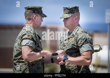 U.S. Marine Corps Sgt. Maj. Jon M. McCloskey, right, inbound battalion sergeant major, 1st Marine Raider Support Battalion (1st MRSB), Marine Corps Forces Special Operations Command (MARSOC), receives the NCO sword from Lt. Col. Bradley Ledbetter, commanding officer, 1st MRSB, MARSOC, during 1st MRSB’s relief and appointment ceremony at Marine Corps Base Camp Pendleton, California, Aug. 14, 2018. McCloskey relieved Sgt. Maj. Bryan L. Marzzarella, outgoing sergeant major, 1st MRSB, MARSOC, of his duties as battalion sergeant major. Stock Photo