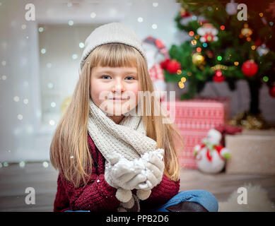 Little girl in a knitted cap on a New Year's background Stock Photo
