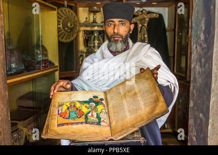 Priest with 1000 year old bible,Azua Mariam, The Painted House, monastery, Zenge Peninsula, Lake Tana, Ethiopia Stock Photo