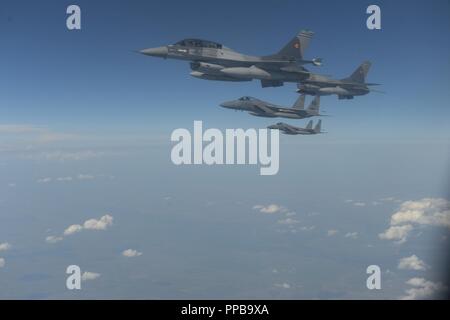 Romanian F-16 Fighting Falcons fly in formation with Massachusetts Air National Guard 131st Expeditionary Fighter Squadron F-15C Eagles above Bucharest, Romania, Aug. 20, 2018. The U.S. works closely with Romania on a range of global challenges, including promoting international peace, security and economic prosperity. Stock Photo
