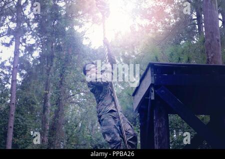 Staff Sgt. Raul Galvin, 519th Military Police Battalion, 16th Military Police Brigade, maneuvers through an obstacle at during the 16th Military Police Brigade Soldier, Noncommissioned Officer and Officer of the Quarter Competition at Fort Stewart, Georgia, Aug. 15, 2018. The obstacle course was one of many events during the two-day competition hosted by the 385th Military Police Battalion. The winners of the competition will go on to compete in the annual 16th Military Police Brigade's Soldier, NCO and Officer of the Year Competition slated for 2019. Stock Photo