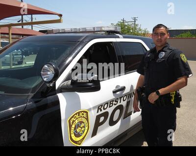 Police Officer Michael Pernell stands next to a new Ford Interceptor Utility SUV on August 17, 2018, at Robstown, Texas. Pernell is also a US Army Reserve Human Resources Officer with the 211th Regional Support Group (RSG) based out of Corpus Christi, Texas. Citizen-soldiers like 1st Lt. Pernell have a wide variety of skill sets which ensure America’s Army Reserve units are trained to deploy bringing capable, combat-ready, and lethal firepower in support of the Army and our joint partners anywhere in the world. Stock Photo