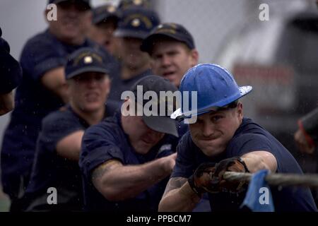 Crewmembers of the Coast Guard Cutter Anthony Petit, homeported in Ketchikan, Alaska, use every ounce of strength in their tug-o-war loss to the crew of the Coast Guard Cutter Sycamore during the Buoy Tender Roundup Olympics at Coast Guard Station Juneau, Alaska, Aug. 22, 2018. The Olympics is a competition that not only builds morale amongst cutter members but also provides a fun alternative to every day training in events such as the chain pull, survival swim and the heat-and-beat. Stock Photo