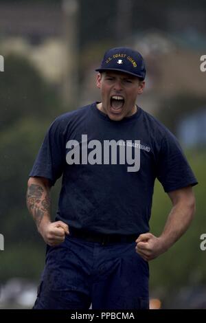 A member of the Coast Guard Cutter Sycamore, homeported in Cordova, Alaska, yells in excitement after taking first place in the tug-o-war competion during the Buoy Tender Roundup Olympics at Coast Guard Station Juneau, Alaska, Aug. 22, 2018. The Olympics is a competition that not only builds morale amongst cutter members but also provides a fun alternative to every day training in events such as the chain pull, survival swim and the heat-and-beat. Stock Photo