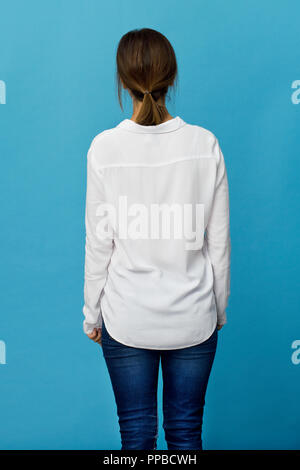 Rear view of elegant young woman wearing white shirt and jeans Stock Photo