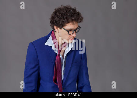 Upset man wearing in blue suit and glasses looking down Stock Photo