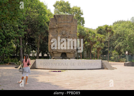A young Mexican girl photographing Aztec sculpture near the entrance to the National Museum of Anthropology in Chapultepec Park, Mexico City Stock Photo