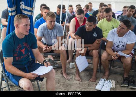 U.S. Marine Corps Pfc. Cameron McCain, amphibious assault technician, Assault Amphibian School Battalion, speaks at a group discussion during the 21 Area Mentorship Workshop Program at Del Mar Beach Resort at Marine Corps Base Camp Pendleton, California, Aug. 24, 2018.  Open and respectful communication and effective conflict resolutions were discussed in group settings. Stock Photo