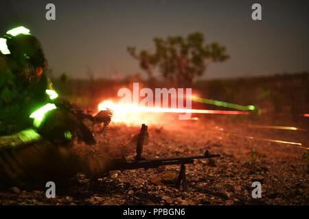 Australian Defence Force members with Charlie Company, 5th Royal Australian Regiment, fire squad automatic weapons during Marine Rotational Force – Darwin’s Exercise Koolendong at Mount Bundey Training Area, Australia, Aug. 22, 2018. Ex Koolendong consisted of multi-lateral training between the U.S., Australia and French forces and included night raids, platoon and company sized live-fire attacks, the air wing, artillery and mortar live-fire and other elements to show full Marine Air-Ground Task Force capabilities in the region. Stock Photo