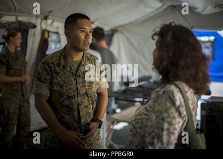 U.S. Navy Petty Officer 1st Class Michael Soto a corpsman with 1st Medical Battalion, 1st Marine Logistics Group, speaks with an attendee during the Humanitarian Assistance Disaster Relief Village demonstration in Los Angeles, Calif., Aug. 28, 2018. The event included static displays from the U.S. Marines, City of Los Angeles public safety agencies, Los Angeles County Office of Emergency Management and several non-profit partners. I MEF provides the Marine Corps a globally responsive, expeditionary, and fully scalable Marine Air Ground Task Force (MAGTF), capable of generating, deploying, and  Stock Photo