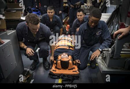 SEA (Aug. 28, 2018) Sailors participate in stretcher bearer training aboard the Arleigh Burke-class guided-missile destroyer USS Carney (DDG 64) Aug. 28, 2018. Carney, forward-deployed to Rota, Spain, is on its fifth patrol in the U.S. 6th Fleet area of operations in support of regional allies and partners as well as U.S. national security interests in Europe and Africa. Stock Photo