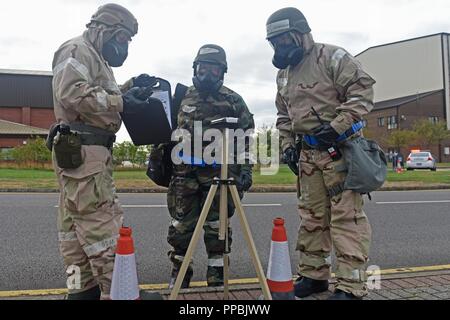 U.S. Air Force Tech. Sgt. David Kurz, 100th Operations Group training manager, Airman 1st Class Austin Hall, 100th Aircraft Maintenance Squadron aircraft propulsion journeyman,  and Staff Sgt. Ryan LaFrance, 100th Aircraft Maintenance Squadron crew chief, evaluate M8 chemical agent detector paper during a mission assurance exercise at RAF Mildenhall, England, Aug. 28, 2018. The exercise was performed to test Mildenhall Airmen and sharpen their response and readiness abilities. Stock Photo