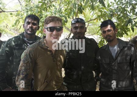 Sri Lanka –Sri Lanka Navy Marines and a U.S. Marine pose for a photo while on a regularly scheduled deployment of the Essex Amphibious Ready Group (ARG) and 13th MEU, August 25, 2018. The San Antonio-class amphibious transport dock USS Anchorage (LPD 23) and the embarked Marines of the 13th MEU conducted a theater security cooperation exercise with the Sri Lankan Navy and Navy Marines.  Part of a growing U.S.-Sri Lanka naval partnership, the exercise was also an opportunity for U.S. Seventh Fleet to explore local logistics support services for visiting naval forces operating throughout the Ind Stock Photo