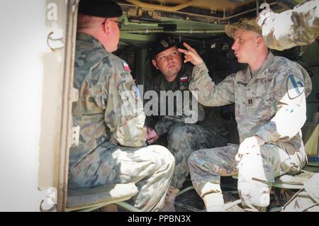 U.S. Army Capt. Ben Nygaard with the 2nd Battalion, 5th Cavalry Regiment (2-5 Cav), 1st Armored Brigade Combat Team (ABCT), 1st Cavalry Division (CD) shows Polish soldiers the inside of an M2A3 Bradley Fighting Vehicle at the Mihail Kogalniceanu Air Base in Romania, Sept. 3, 2018. U.S. Army leaders with 2-5 Cav, 1st ABCT, 1st CD met with Polish soldiers to discuss future joint training opportunities in support of Atlantic Resolve, an enduring training exercise between NATO and U.S. forces. Stock Photo