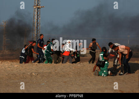 Gaza. 24th Sep, 2018. Palestinian medics and protesters carry a wounded man during clashes with Israeli troops on a beach near the maritime border with Israel in the northern Gaza Strip, on Sept. 24, 2018. Clashes between Palestinian protesters and Israeli soldiers killed one Palestinian and injured 50 others on the border between the northern Gaza Strip and Israel, the Gaza health ministry said. Credit: Xinhua/Alamy Live News Stock Photo