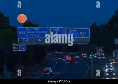 Birmingham, UK. 24th September, 2018. The harvest moon rises over the busy M42 motorway just south of Birmingham, West Midlands, UK. Peter Lopeman/Alamy Live News. Stock Photo