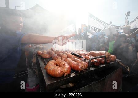 Buenos Aires, Argentina. 24th Sep, 2018. A sausage seller makes the victory sign, symbol of left-wing political movements in Argentina, in a protest against the austerity policy of the conservative government. The Argentine Federation of Trade Unions has called for a national strike over President Macri's economic policies. The protest is directed against austerity measures that the government has agreed with the International Monetary Fund (IMF). Credit: Claudio Santisteban/dpa/Alamy Live News Stock Photo