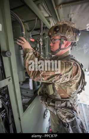 U.S. Army Reserve Pfc. Michael Birkett, 137th Quartermaster Company, 311th Sustainment Command, operates a Laundry Advanced System (LADS) during Combat Support Training Exercise (CSTX) 86-18-02 at Fort McCoy, Wis., August 16, 2018.  This is the second CSTX of the summer for the 86th Training Division. The CSTX exercise is a large-scale training event where units experience tactical training scenarios specifically designed to replicate real-world missions. Stock Photo