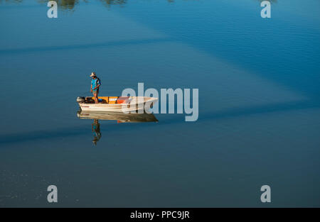 a man standing on a boat on Victoria River, Timber Creek, Northern Territory, Australia Stock Photo