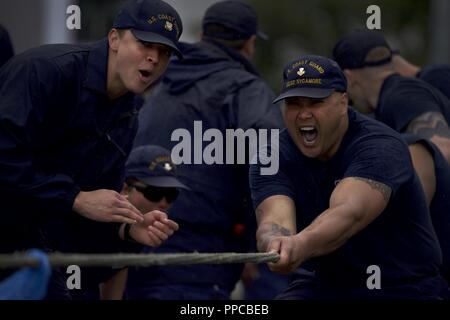 Members of the Coast Guard Cutter Sycamore fight passed the point of exhaustion during the tug-o-war competition as part of the Buoy Tender Olympics at Coast Guard Station Juneau, Alaska, Aug. 22, 2018. The Olympics is a competition that not only builds morale amongst cutter members but also provides a fun alternative to every day training in events such as the chain pull, survival swim and the heat-and-beat. Stock Photo