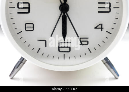 Close up of the bottom half of a white analogue alarm clock. Stock Photo