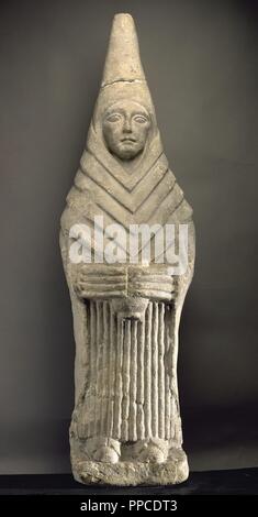 Female Iberian sculpture in offering attitude, carrying a offering glass. 2nd-3rd centuries BC. Limestone. Robed and veiled conical miter. From the Sanctuary of Cerro de Los Santos (Montealegre del Castillo, Albacete province). National Archaeological Museum. Madrid. Spain. Stock Photo