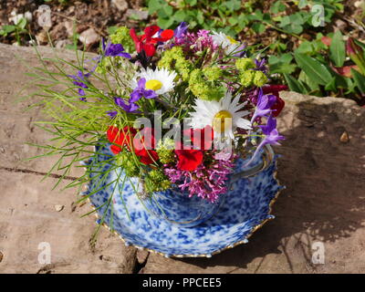 teacup and saucer with flower arrangement Stock Photo