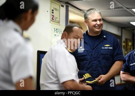 Cmdr. Michael Sarnowski, Commanding officer of the Coast Guard Cutter Tahoma, is presented with gifts from Columbian naval officials in Cartagena, Colombia for the annual UNITAS exercise Aug. 30, 2018. UNITAS consists of a variety of exercises and multinational exchanges to enhance interoperability, increase regional stability, and build and maintain regional relationships with countries throughout the region through joint, multinational and interagency exchanges and cooperation. Stock Photo