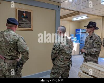 British Army Brigadier Simon Humphrey (left), commander of the Kabul Security Force (KSF), and Oklahoma Army National Guard (OKARNG) members (right) of 1st Squadron, 180th Cavalry Regiment, 45th Infantry Brigade Combat Team, observe a recently unveiled plaque after a dedication ceremony at the newly remodeled New Kabul Compound (NKC) flight terminal on Friday, Aug. 31, 2018 in Kabul, Afghanistan. The “Hughie Terminal” at NKC is named after the late Poteau, Oklahoma resident, Sgt. Buddy James “Doc” Hughie, member of Charlie Company, 1st Battalion, 180th Infantry Regiment, who was killed in acti Stock Photo