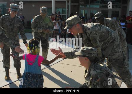 Capt. Josiah Hennig, an explosive ordnance disposal officer with the 20th CBRNE Command located on Aberdeen Proving Ground, Md., gives a high five to a young student from Deerfield Elementary School, Edgewood, Md., as she arrives for her first day of school Sept. 4. Hennig is joined by fellow Soldiers, from left, Pfc. Rosy Atristain, Sgt. Michael Burnett, Spc. William Pridgen and Spc. Elizabeth Armstrong. Stock Photo