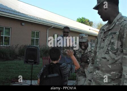 Lt. Col. Terrell Jones, command chaplain for the 20th CBRNE Command from Aberdeen Proving Ground, Md., gives a high five to a Deerfield Elementary School student as Spc. William Pridgen and Minister Stephen Williamston look on. The Soldiers were on hand to wish students well as they start the new school year. ( Stock Photo