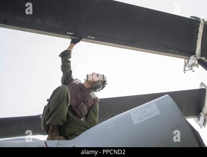 INDIAN OCEAN (Aug. 20, 2018) Marine Corps Cpl. Matthew Regan, from Tampa, Fla., assigned to the Marine Light Attack Helicopter detachment of Marine Medium Tiltrotor Squadron (VMM) 166, performs a pre-flight inspection on a UH-1Y Venom helicopter from the flight deck of San Antonio-class amphibious transport dock USS Anchorage (LPD 23) during a regularly scheduled deployment of the Essex Amphibious Ready Group (ARG) and 13th Marine Expeditionary Unit (MEU). The Essex ARG/13th MEU is a capable and lethal Navy-Marine Corps team deployed to the 7th fleet area of operations to support regional stab Stock Photo